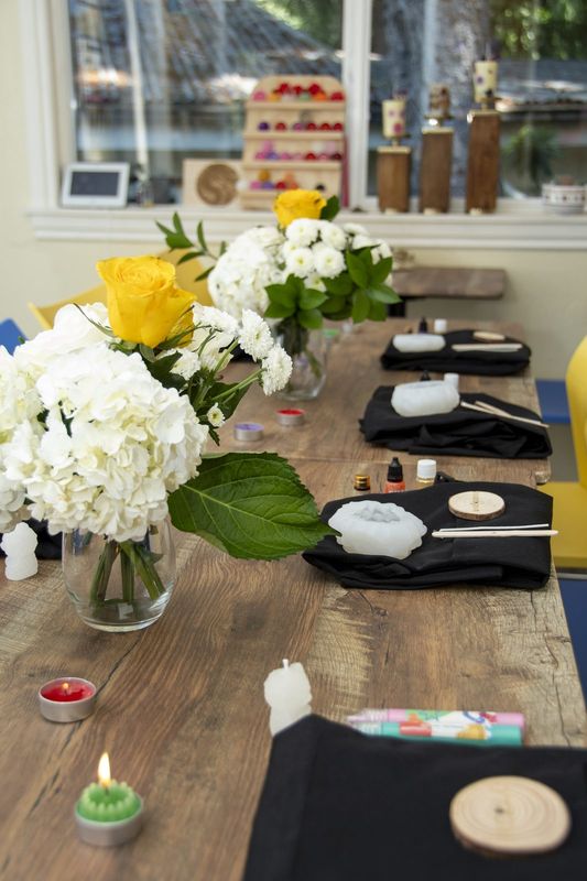 The table set with aprons, tealights and white hydrangeas